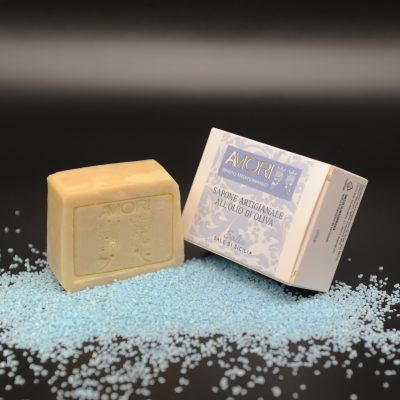 foto sapone al sale marino SALI'A Sapone artigianale all'olio di oliva al profumo di sale marino di Sicilia. Il nostro sapone è fatto secondo un’antica ricetta siciliana del 1800 tramandata di generazione in generazione. Produciamo seguendo il metodo a caldo, per conservare inalterate le proprietà del nostro puro olio di oliva. L’Olivo è il primo albero citato nella storia ed è uno dei più diffusi ed amati in Sicilia. Il suo olio è ricco di acido oleico (circa il 62%), con grandi proprietà nutrienti ed emollienti per la pelle. Il sale marino richiama la purezza del mare, regalando freschezza e benessere. Un gesto semplice, che rispetta la natura e si prende cura di te.